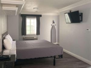格伦代尔Motel 6 Glendale CA Pasadena Burbank Los Angeles的一间带床和平板电视的卧室