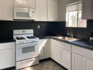 a white kitchen with a stove and a sink at Motel 6 Glendale CA Pasadena Burbank Los Angeles in Glendale