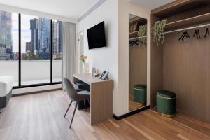 a hotel room with a desk and a window at Best Western Queen Victoria Market Hotel in Melbourne