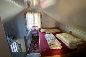 a attic bedroom with a bed and a staircase at Hytte at Oyvoll in Farsund in Farsund