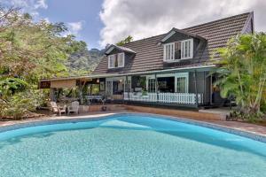 a house with a swimming pool in front of a house at Fare Haurevaiti Moorea in Paopao
