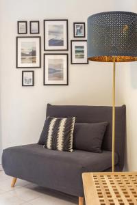 ein blaues Sofa im Wohnzimmer mit Lampe in der Unterkunft Green Apartment Catania in Catania