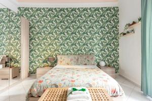 ein Schlafzimmer mit einem Bett und einer grünen Wand in der Unterkunft Green Apartment Catania in Catania
