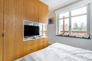 a bedroom with a television in a wooden cabinet at Apartamenty Panorama Szczawnica in Szczawnica
