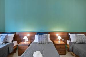 a room with two beds and a couch and lamps at Morina Court - St Julians Seaside Bliss Apartments and Penthouse by ShortletsMalta in St. Julianʼs