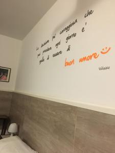 una escritura en la pared sobre un inodoro en un baño en Bed & Breakfast Hostel H24, en Ragusa