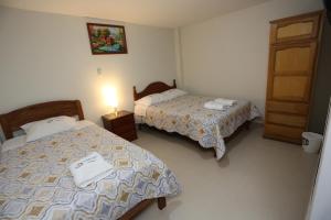 um quarto de hotel com duas camas e uma porta em Witobi Hostal em Cajamarca