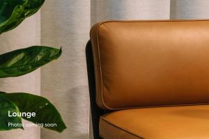 a brown leather chair in front of a curtain at No. 284 powered by Sonder in Boston