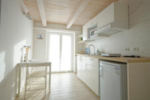 a kitchen with white cabinets and a table and a window at Porto d'aMare - Rooms in Porto Recanati