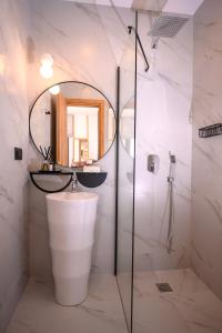 een badkamer met een wastafel en een spiegel bij Sofi Mar - Plomari - The place to be in Plomarion