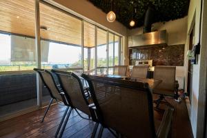uma sala de jantar com cadeiras, uma mesa e janelas em Beach Side Secret -SEVEN Hotels and Resorts- em Ginoza