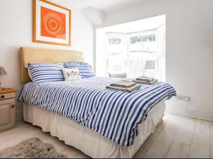 クーム・マーティンにあるSunsetのベッドルーム1室(青と白のストライプの毛布付きのベッド1台付)