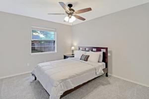 een witte slaapkamer met een bed en een plafondventilator bij cozy house Saginaw TX 3BR 2BA Sleeps 10 just 12 minutes downtown fort worth in Saginaw