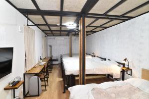Pokój z 3 łóżkami, stołem i krzesłami w obiekcie Motel inn Minami Otaru / Vacation STAY 50438 w mieście Otaru