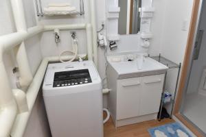 baño pequeño con lavabo y lavadora en Motel inn Minami Otaru / Vacation STAY 50444, en Otaru