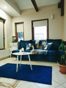 a living room with a blue couch and a table at Rákóczi Guesthouse Miskolc in Miskolc