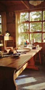 a wooden table in a kitchen with a large window at Casa del río in Cochrane
