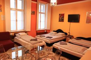 Sala de estar con 3 camas y mesa en Astoria Centrum Studio Apartment, en Budapest