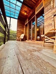 an empty porch of a wooden house with windows at Winwood Ella in Ella