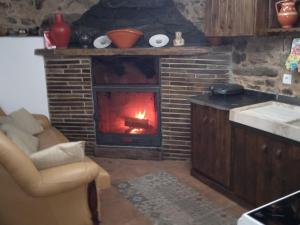 a kitchen with a fireplace with a fire in it at Casa da Ana - Um refúgio na montanha in Arouca