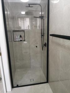 um chuveiro com uma porta de vidro na casa de banho em Eight Mile Plains House em Brisbane