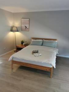 a bedroom with a bed with a table and a lamp at Eight Mile Plains House in Brisbane