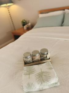 a trio of three jars sitting on top of a bed at Eight Mile Plains House in Brisbane