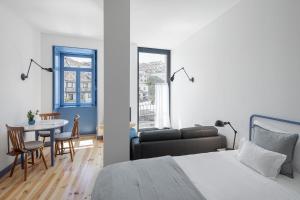a bedroom with a bed and a table and a couch at Pensão Luisinha by Casas com Estória Boutique Houses in Santa Comba Dão
