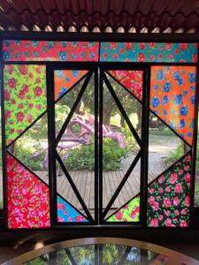 ein Buntglasfenster mit Gartenblick in der Unterkunft Planta Glamp Farm in Santa María Huatulco
