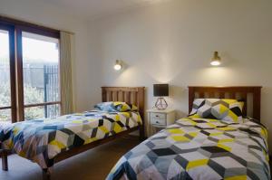 a bedroom with two beds and a window at Sandy Bottoms in Point Lonsdale