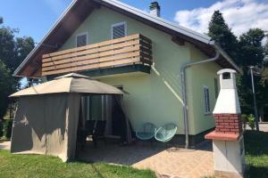 ein kleines Haus mit Stühlen und einer Heizung davor in der Unterkunft Holiday house with a parking space Fuzine, Gorski kotar - 20330 in Fužine