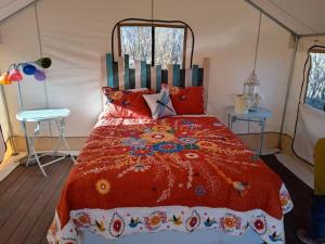 a bedroom with a red bed in a tent at Cozy Glamp Tents at Wildland Gardens in Joseph