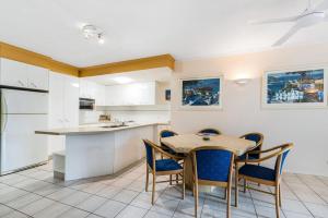Una cocina y un comedor con mesa y sillas. en 7 Como Noosa, en Noosaville