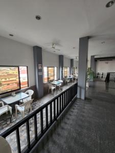 un restaurante con mesas y sillas en un balcón en New Kong's Hotel, en Olóngapo