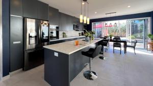 a kitchen with black cabinets and a dining room at Sea Winds Bungalow - Tierra Del Sol Aruba in Noord +20 photos