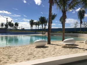 uma piscina com duas espreguiçadeiras na praia em GBU's Studio with Balcony at Azure North Pampanga em San Fernando