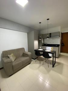 sala de estar con sofá y mesa en Studio charmoso e aconchegante, en Brasilia