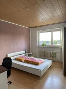 a bedroom with a bed and a desk and two windows at Gemütliche, helle Wohnung im Luftkurort Dansenberg in Kaiserslautern