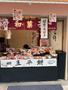 einen Essensstand mit asiatischer Schrift auf der Vorderseite in der Unterkunft 天下茶屋浪漫满屋 in Osaka