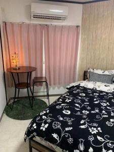 Schlafzimmer mit einem Bett, einem Tisch und einem Fenster in der Unterkunft 天下茶屋浪漫满屋 in Osaka