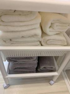 einen Haufen Handtücher auf einem Regal in einem Schrank in der Unterkunft 天下茶屋浪漫满屋 in Osaka