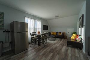 eine Küche und ein Wohnzimmer mit einem Kühlschrank und einem Tisch in der Unterkunft Modern, Luxury 2 Bedroom Apt in Prime Location in Schenectady