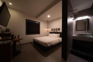 um quarto com uma cama, um lavatório e um espelho em No25 Hotel Yeonsan em Busan