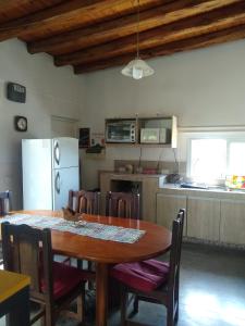 cocina con mesa de madera y nevera en Casa Entelequia en Las Compuertas