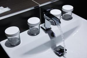 un lavandino in bagno con acqua che esce da un rubinetto di Pension Dvořák a Karlovy Vary