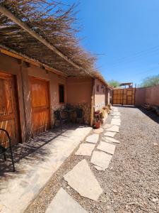 una pasarela de piedra que conduce a un lado de una casa en Masairi, en San Pedro de Atacama