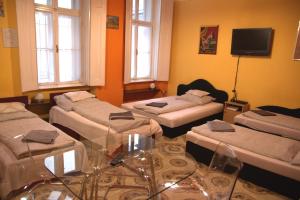 ブダペストにあるAstoria Centrum Studio Apartmentのベッド4台とガラスのテーブルが備わる客室です。