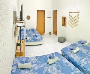 a room with three blue beds in a room at OsteL By OstiC in Bandung