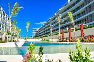 a swimming pool with chairs and umbrellas in front of a building at Apartamento vista al Mar lateral Panoramic View,Spectacular building,Pools, Beach Morros zoe ultimo piso in Cartagena de Indias