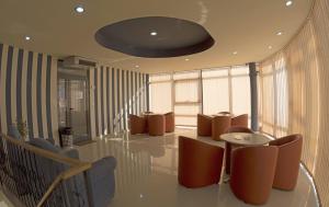 - une salle d'attente avec des chaises brunes et une table dans l'établissement Motel Alexander, à Olteniţa